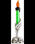 Skeleton hand candle holder with green drip taper candle and skull cluster base