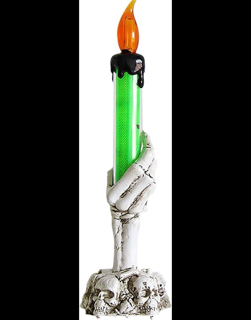Skeleton hand candle holder with green drip taper candle and skull cluster base