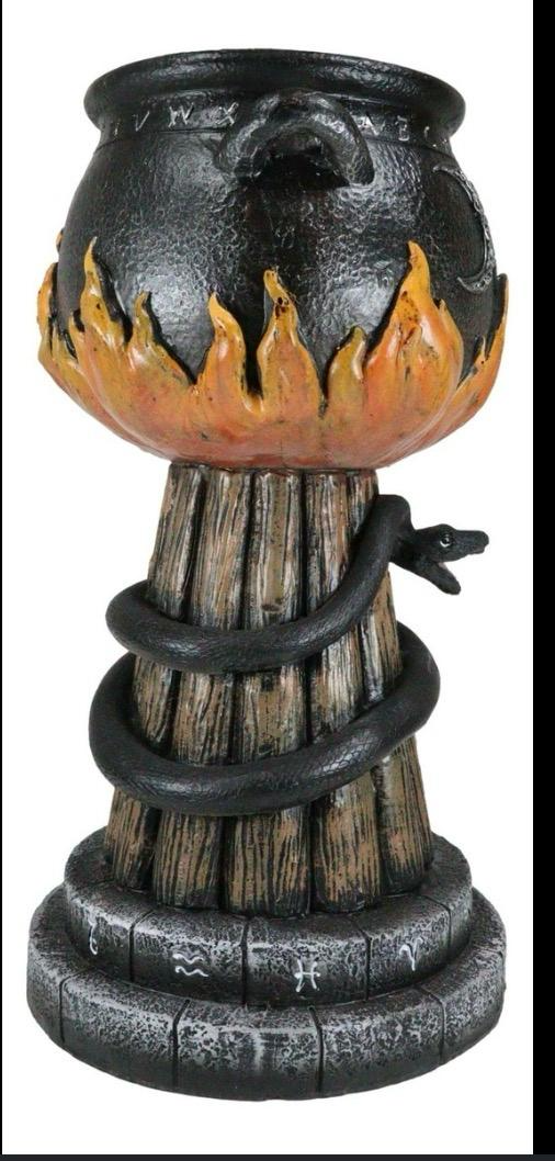 Witch's cauldron candle holder with black snake coiled around log base and flame detail