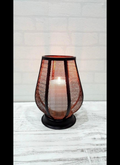 Black wire mesh tulip lantern candle holder glowing with warm amber candlelight